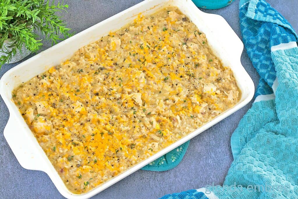 Creamy One Pan Chicken and Rice fully baked in a white ceramic 9x13 baking pan.