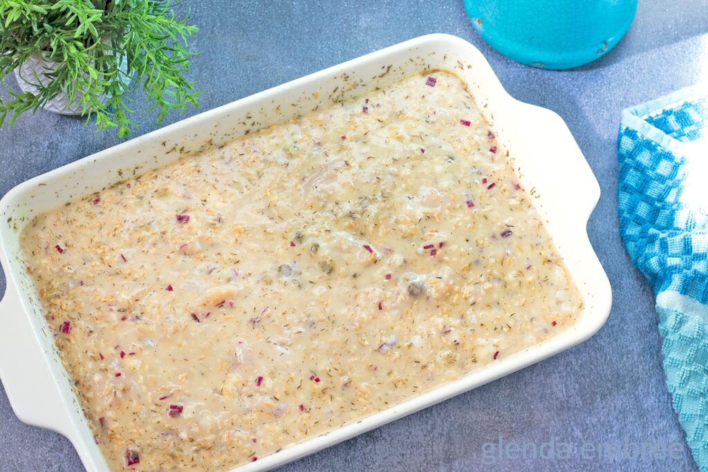 Creamy Chicken and Rice Casserole in a white 9x13 baking dish and ready for the oven.