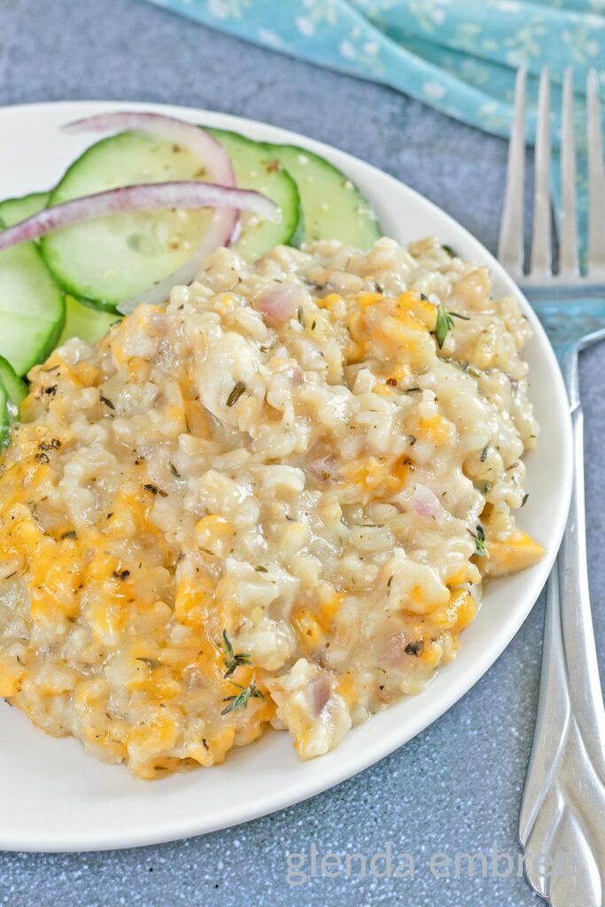 Creamy One Pan Chicken and Rice on a white plate with a cucumber salad.