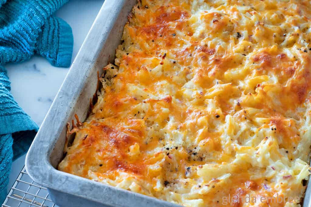 Baked Hashbrown Casserole/ Funeral Potatoes in a metal 9x13 pan.