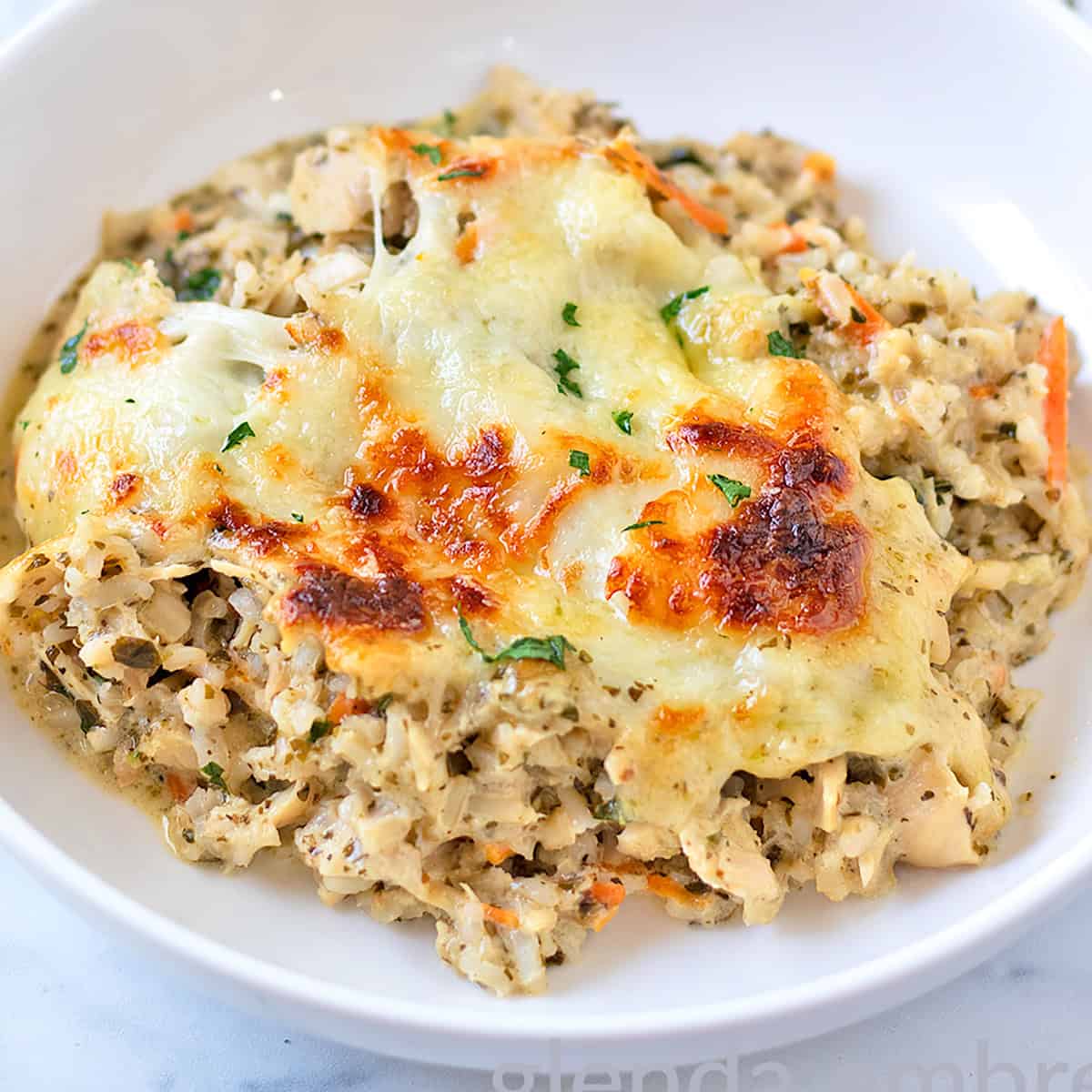 Pesto Alfredo Chicken and Rice served in a white ceramic low-side bowl.