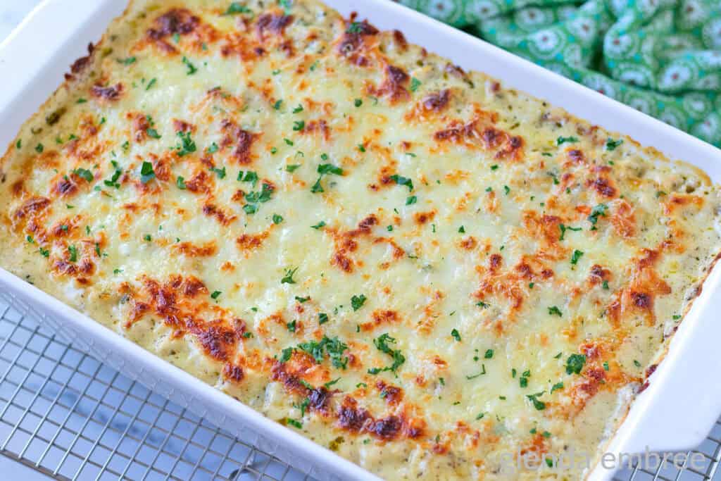 Baked Pesto Alfredo Chicken and Rice in a white ceramic 9x13 pan.