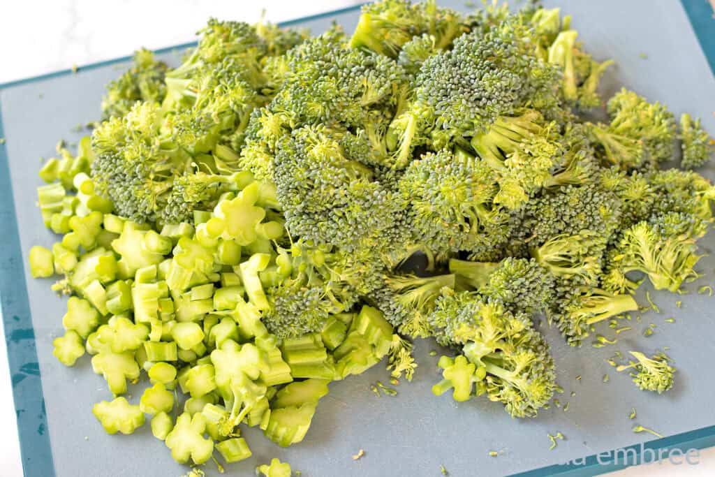 Fresh broccoli chopped on a cutting board.