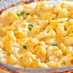 Baked Cauliflower Gratin, (Cauliflower with Cheese Sauce), Cauliflower Cheese, Cheesy Cauliflower in a clear glass baking dish with a sprinkle of chopped parsley.