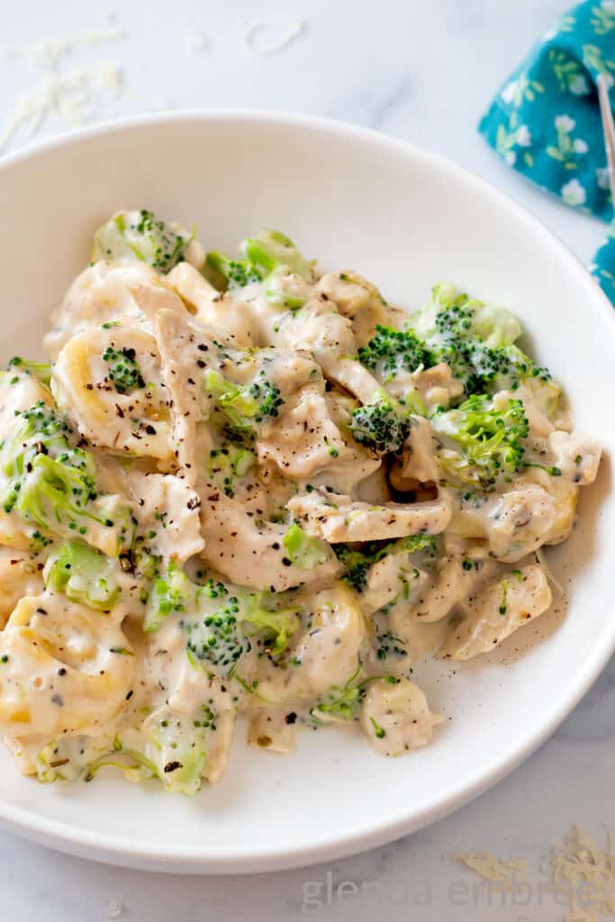 Creamy Chicken Tortellini with Broccoli in a white ceramic bowl.