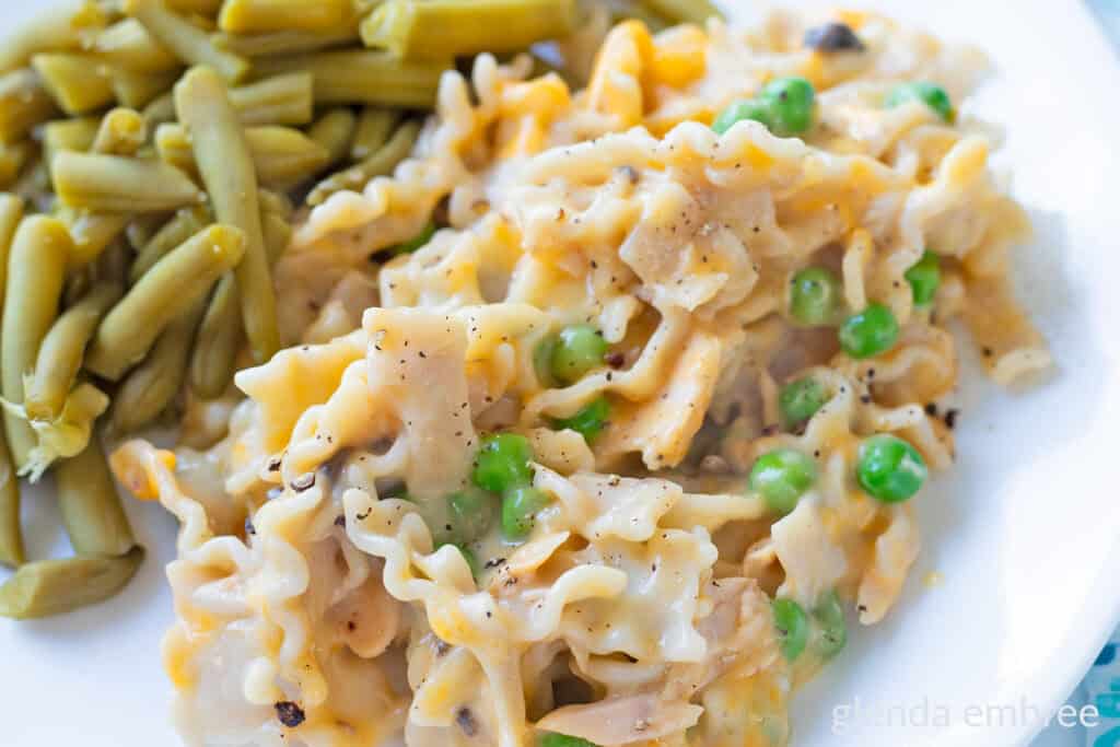 Tuna Casserole with Cream of Mushroom Soup on a white plate with green beans.