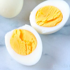 Steamed hard-boiled egg cut in half on a marble countertop.