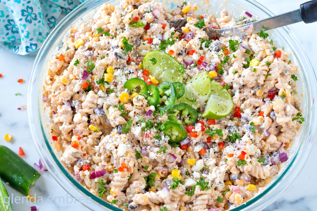 Street Corn Pasta Salad in a clear glass mixing bowl.