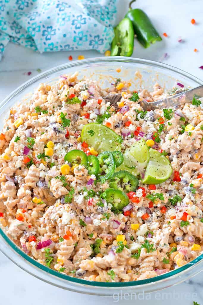 Street Corn Pasta Salad in a clear glass mixing bowl.