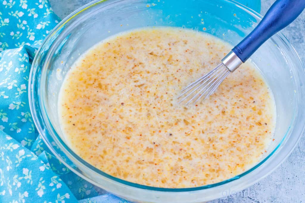 Jezebel Sauce ingredients whisked together in a clear glass bowl.