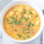 Sausage and Gnocchi Soup in a white ceramic bowl.