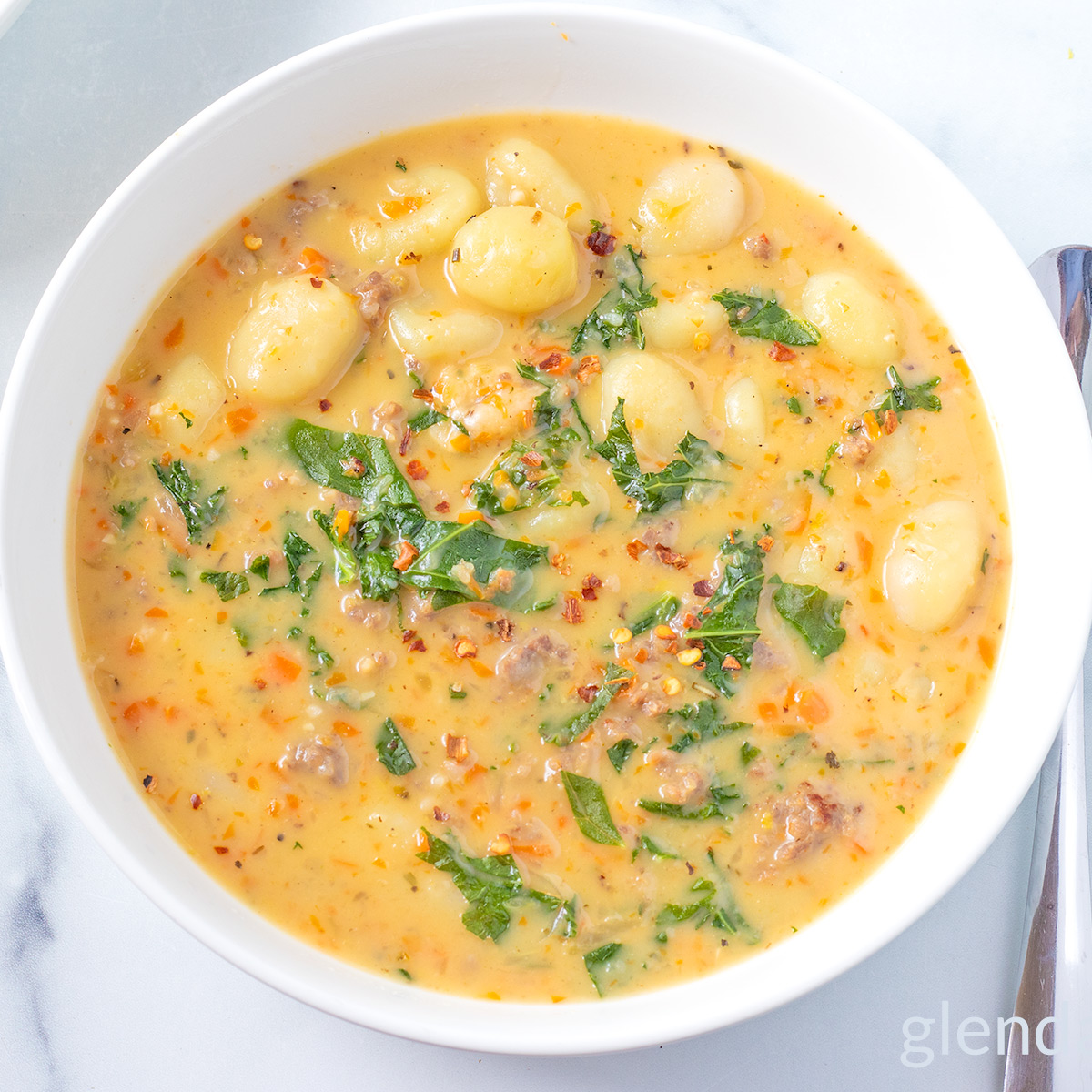 Sausage and Gnocchi Soup in a white ceramic bowl.