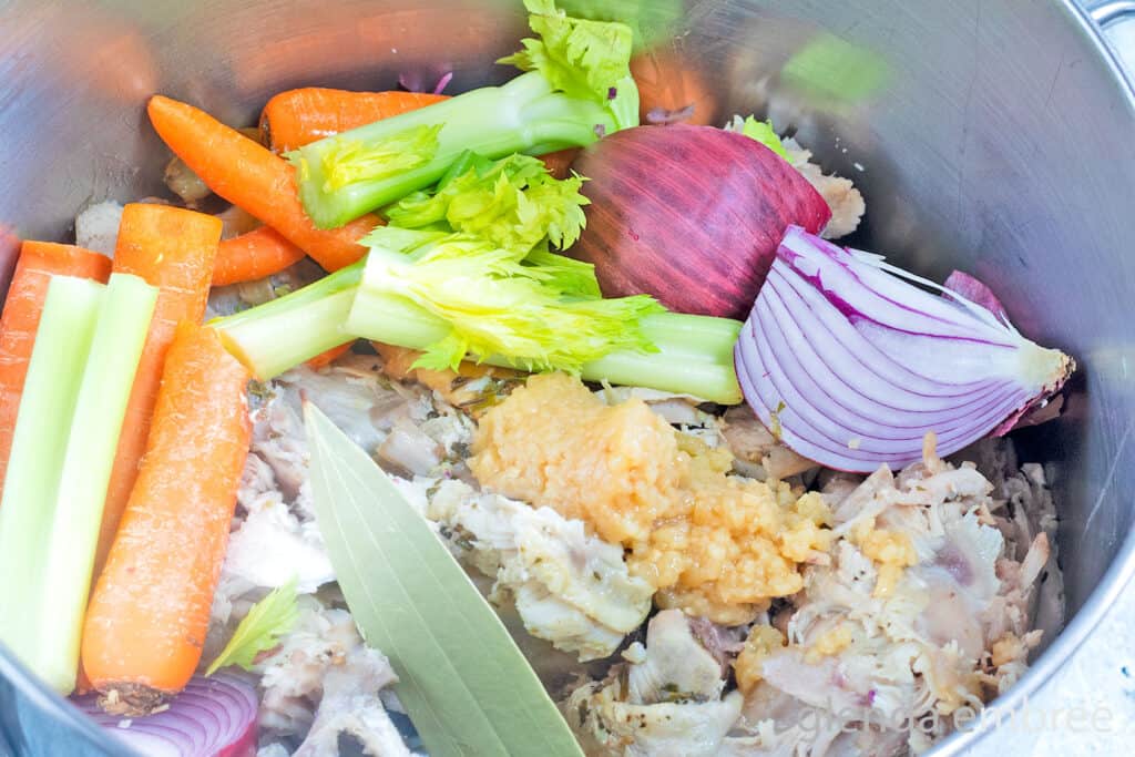 Turkey carcass and veggies in a stock pot with garlic, bay leaves and salt to cover with water and make into bone broth.