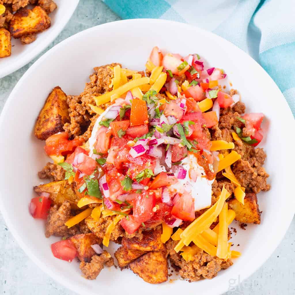 Taco bowl with taco potatoes in a white ceramic bowl on a concrete countertop.