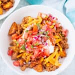 Taco bowl with taco potatoes in a white ceramic bowl on a concrete countertop.