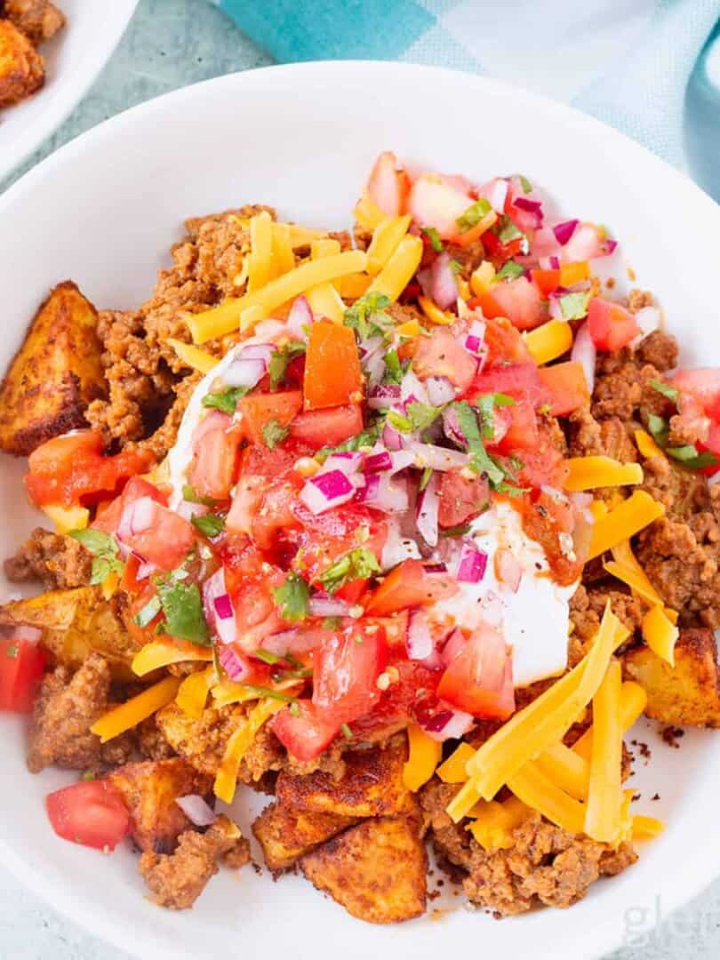 Taco bowl with taco potatoes in a white ceramic bowl on a concrete countertop.