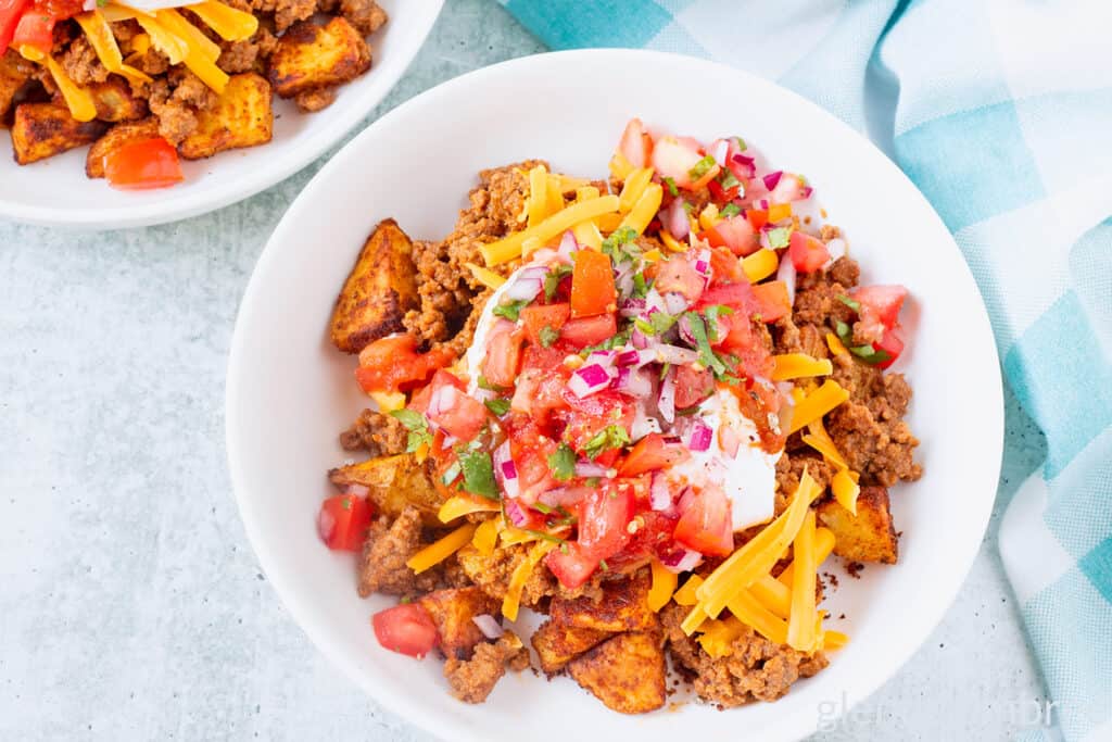 Taco bowl with taco potatoes in a white ceramic bowl on a concrete countertop.
