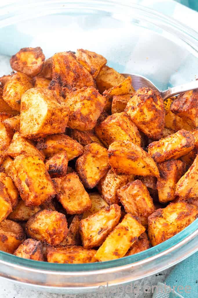 Roasted Taco Potatoes (Taco Fries) in a clear glass bowl on a concrete countertop.
