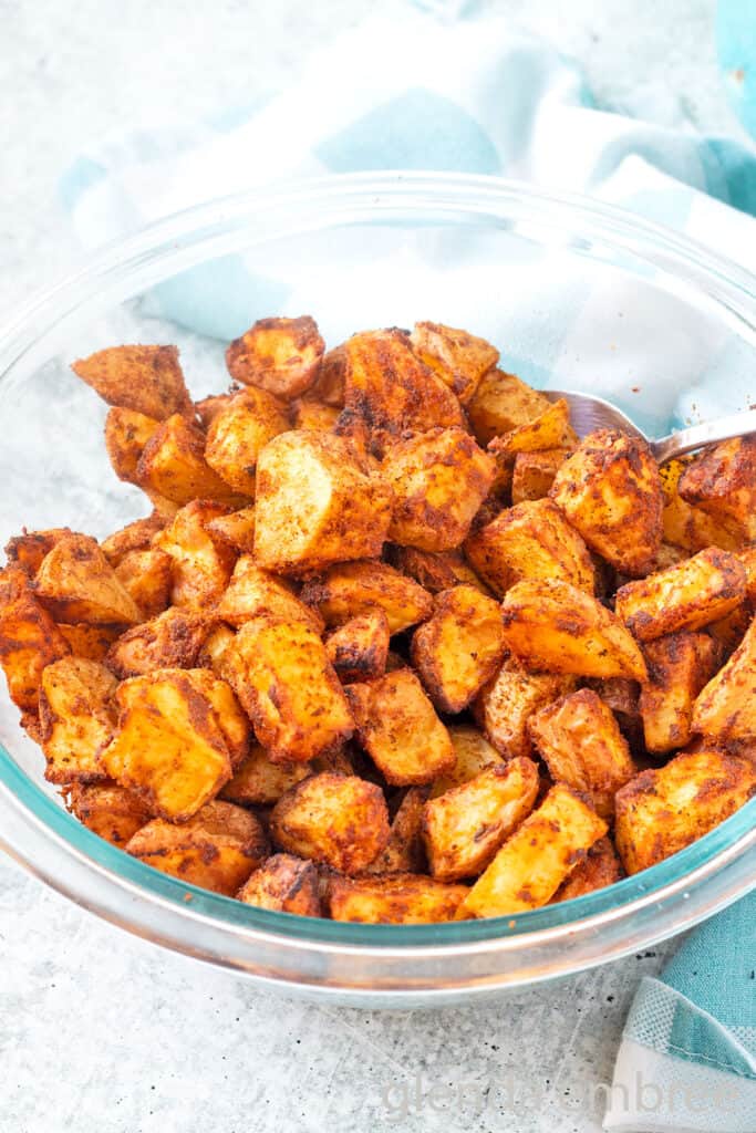 Roasted Taco Potatoes (Taco Fries) in a clear glass bowl on a concrete countertop.