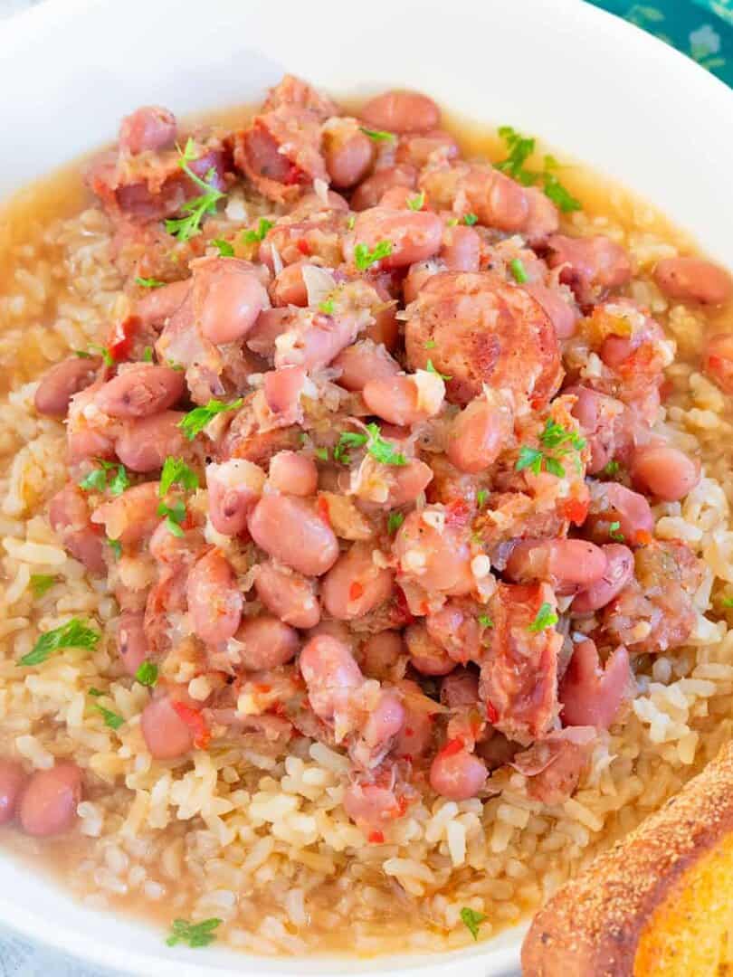 Red Beans and Rice served in a white ceramic bowl with a slice of toasted garlic bread.