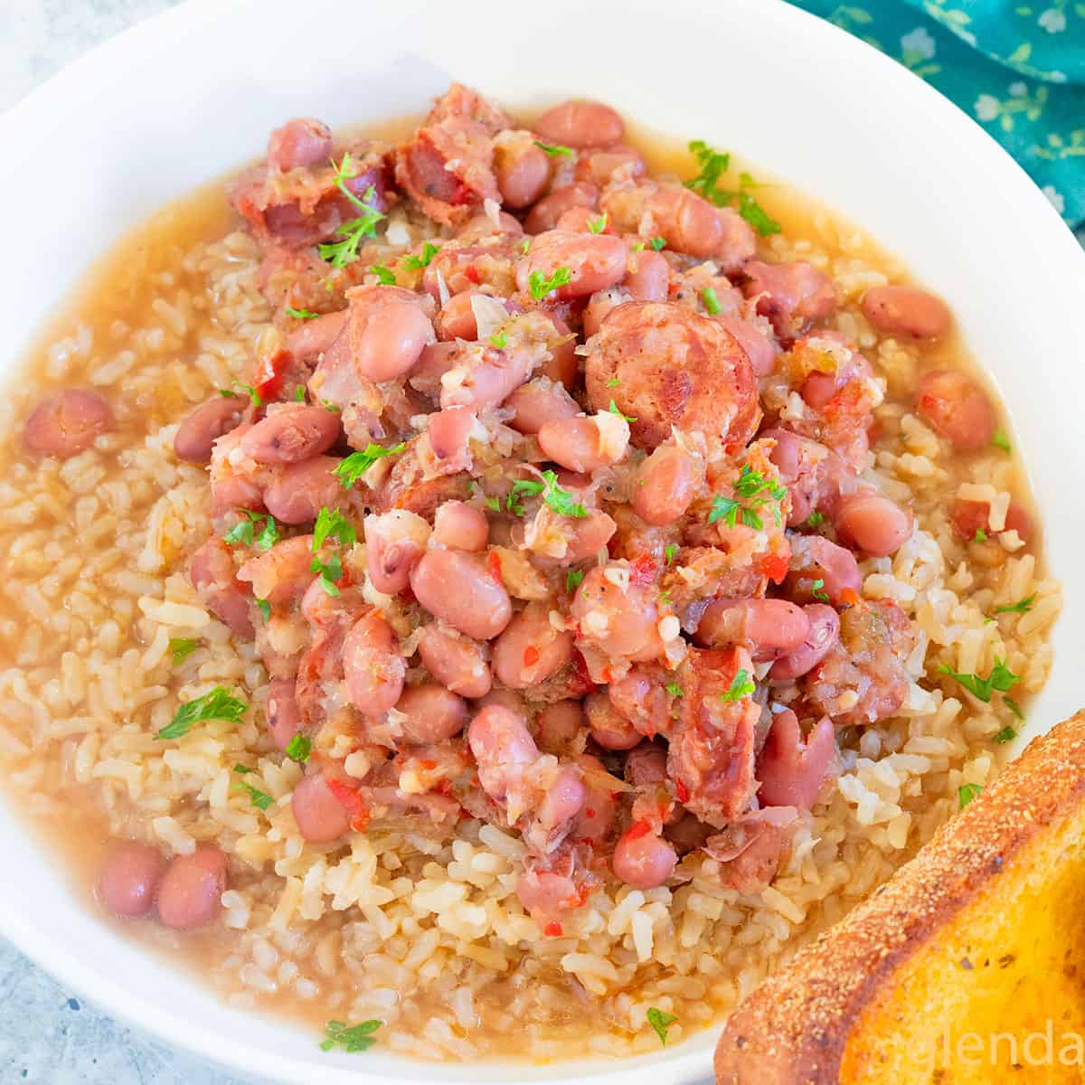 Red Beans and Rice served in a white ceramic bowl with a slice of toasted garlic bread.