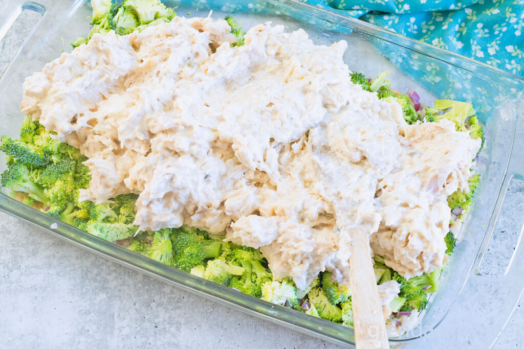 Adding the chicken layer in a clear glass baking dish as Chicken Broccoli Cheese Casserole  (Chicken Casserole) is assembled.