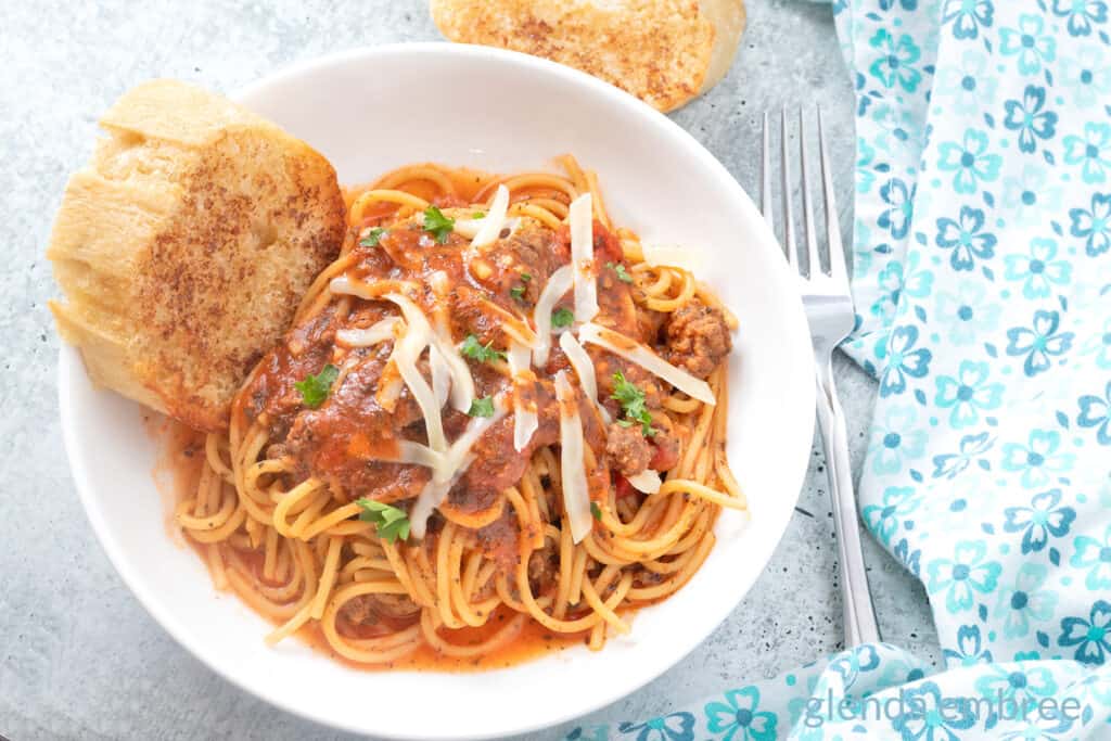 Best Easy One Pot Spaghetti in a white pasta bowl with broiled baguette toast.