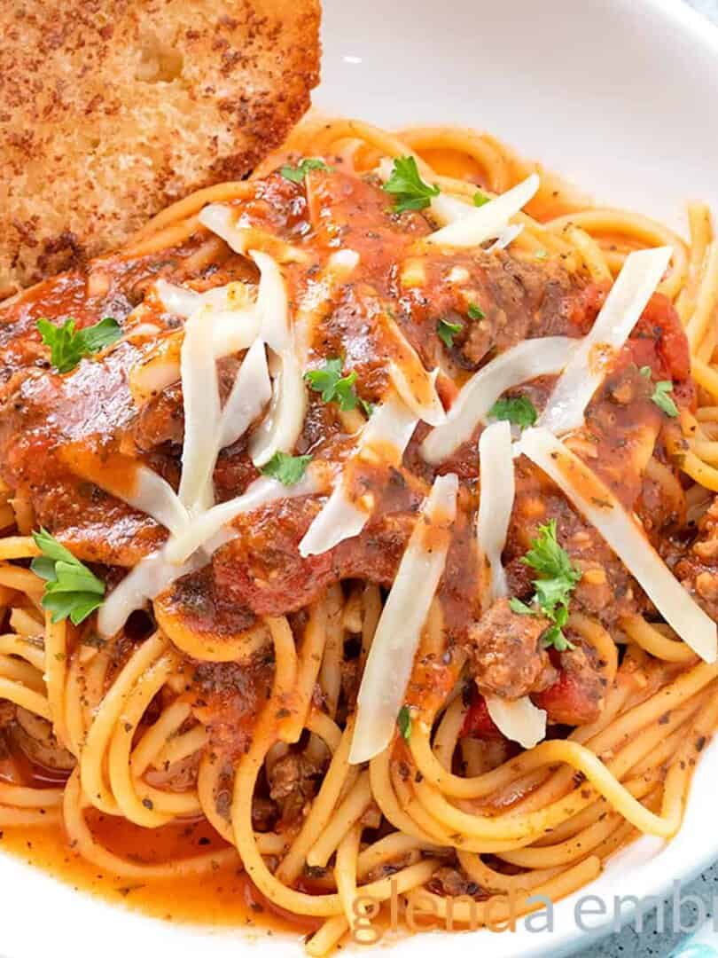 Best Easy One Pot Spaghetti in a white pasta bowl with broiled baguette toast.