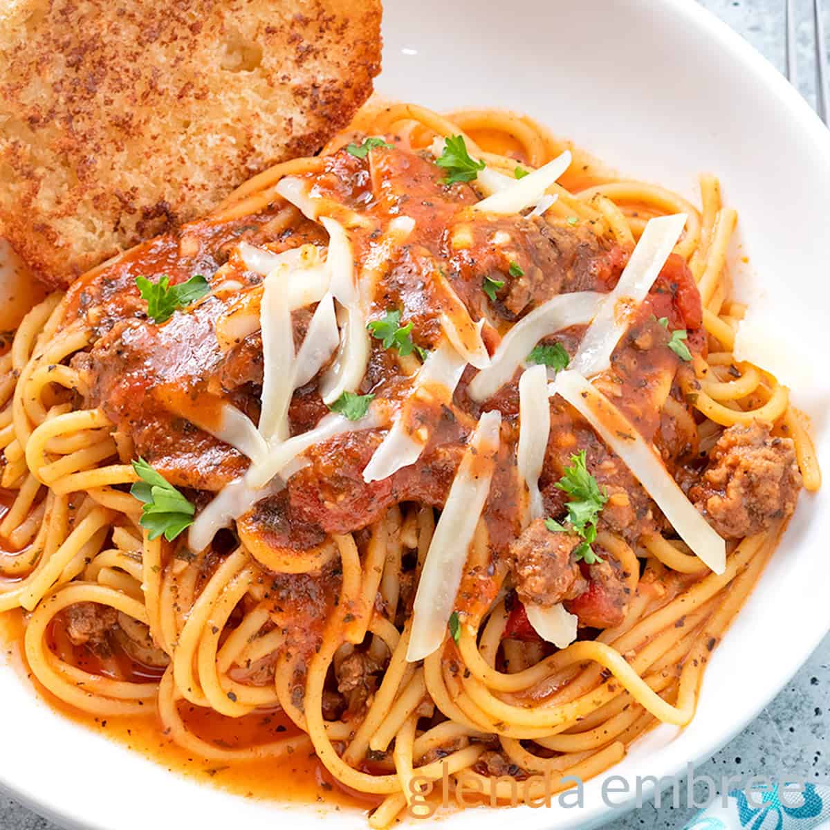 Best Easy One Pot Spaghetti in a white pasta bowl with broiled baguette toast.