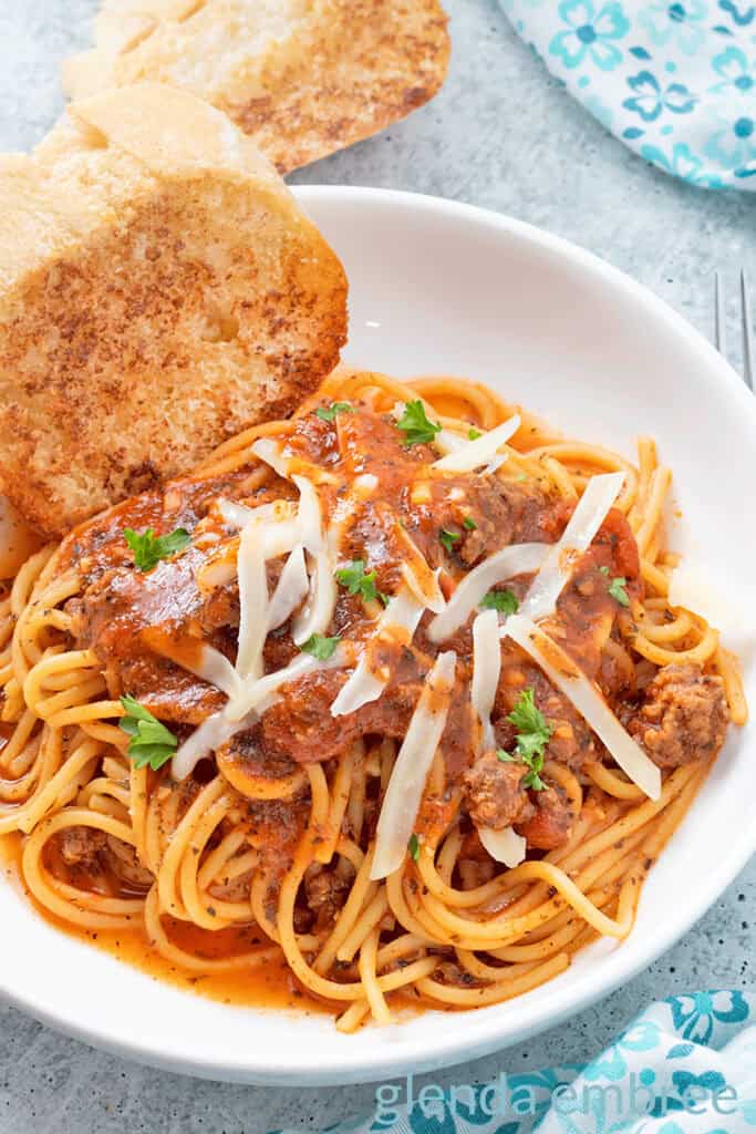 Best Easy One Pot Spaghetti in a white pasta bowl with broiled baguette toast.