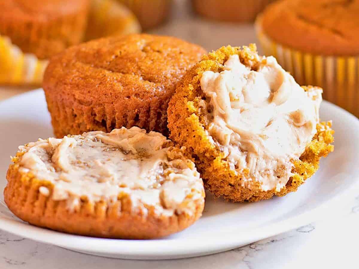 Gluten Free Pumpkin Muffins slathered with Maple Butter and sitting on a white plate.